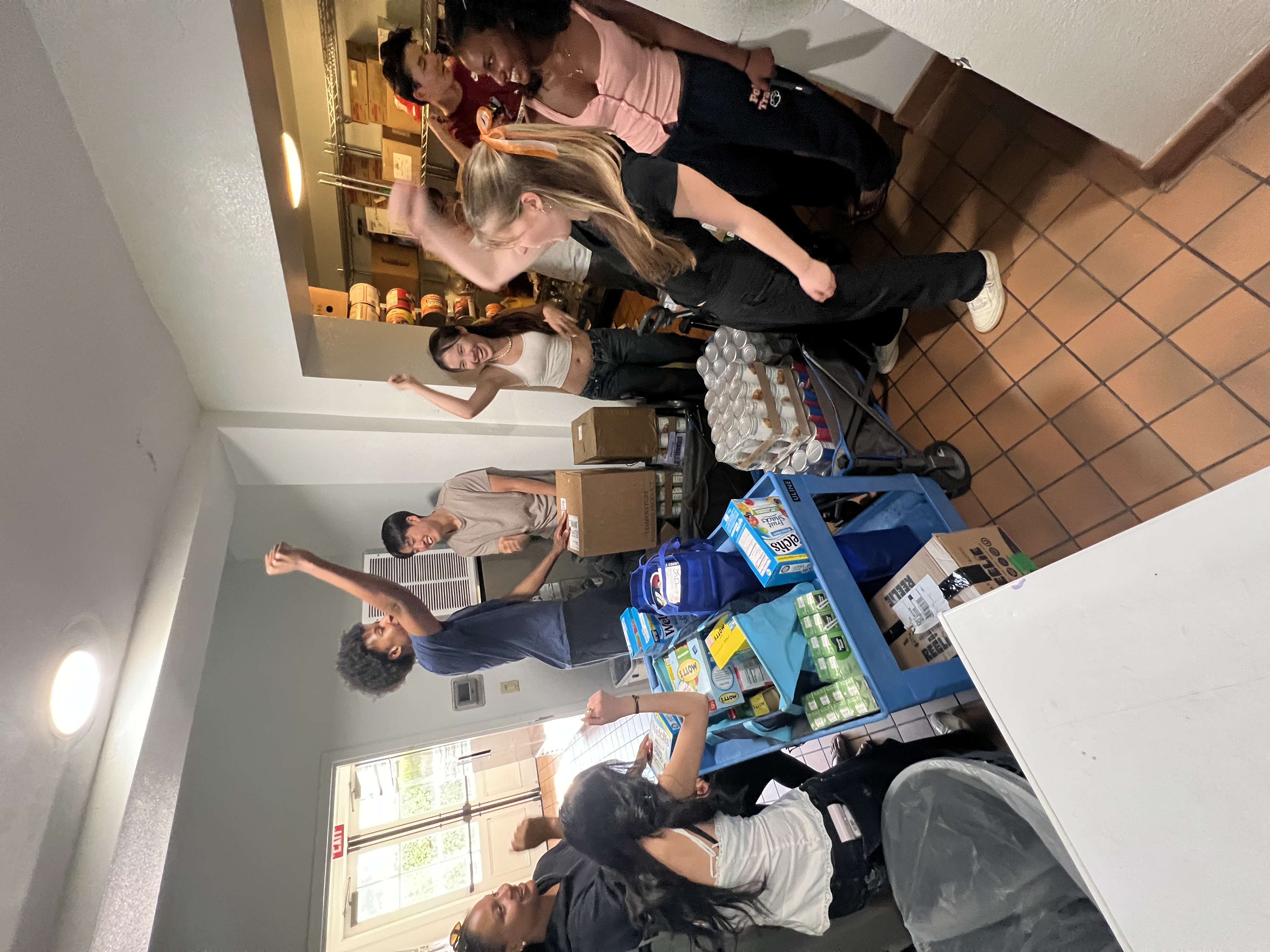 Volunteers celebrating with a cart full of donated food