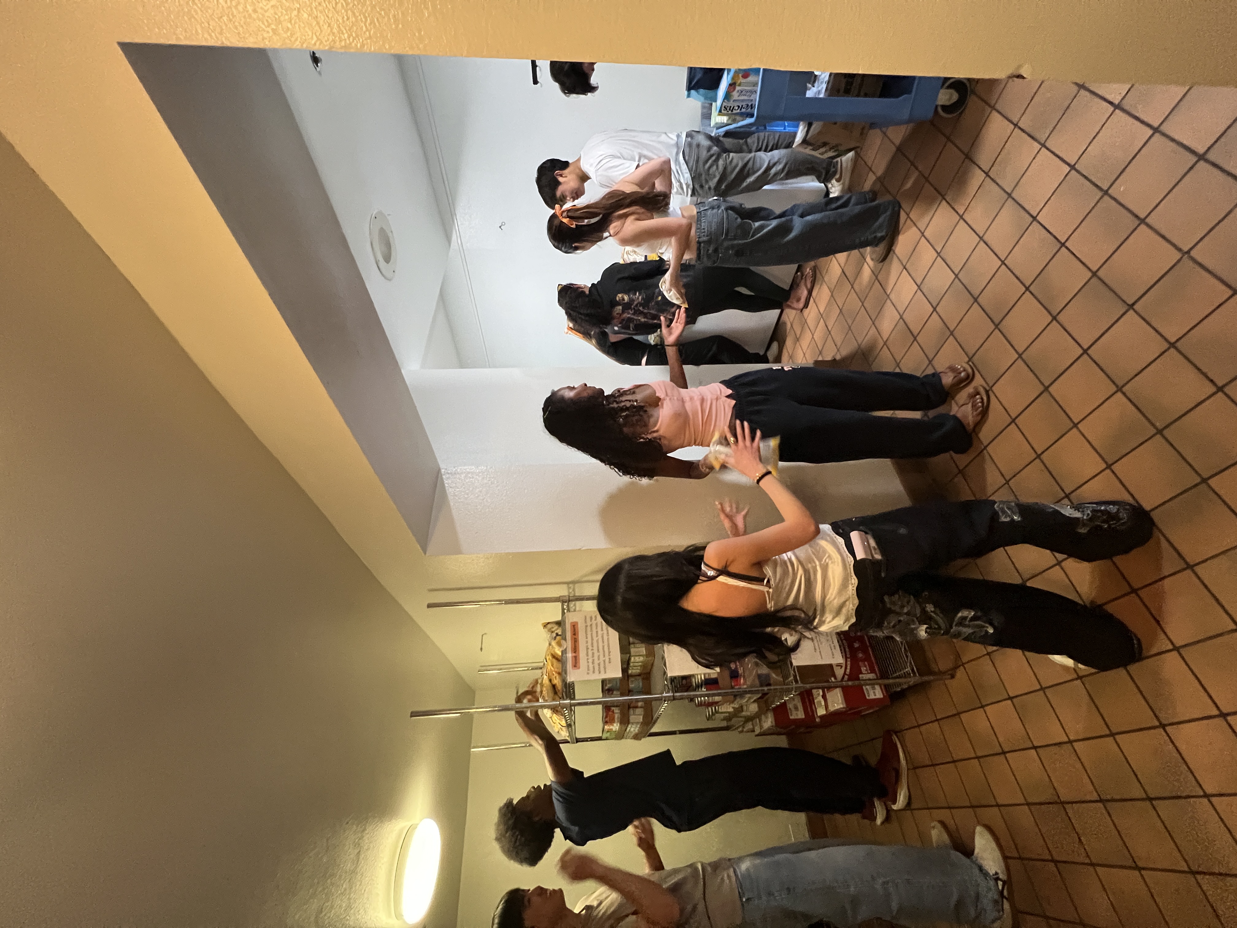 Students organizing snacks and supplies in the pantry