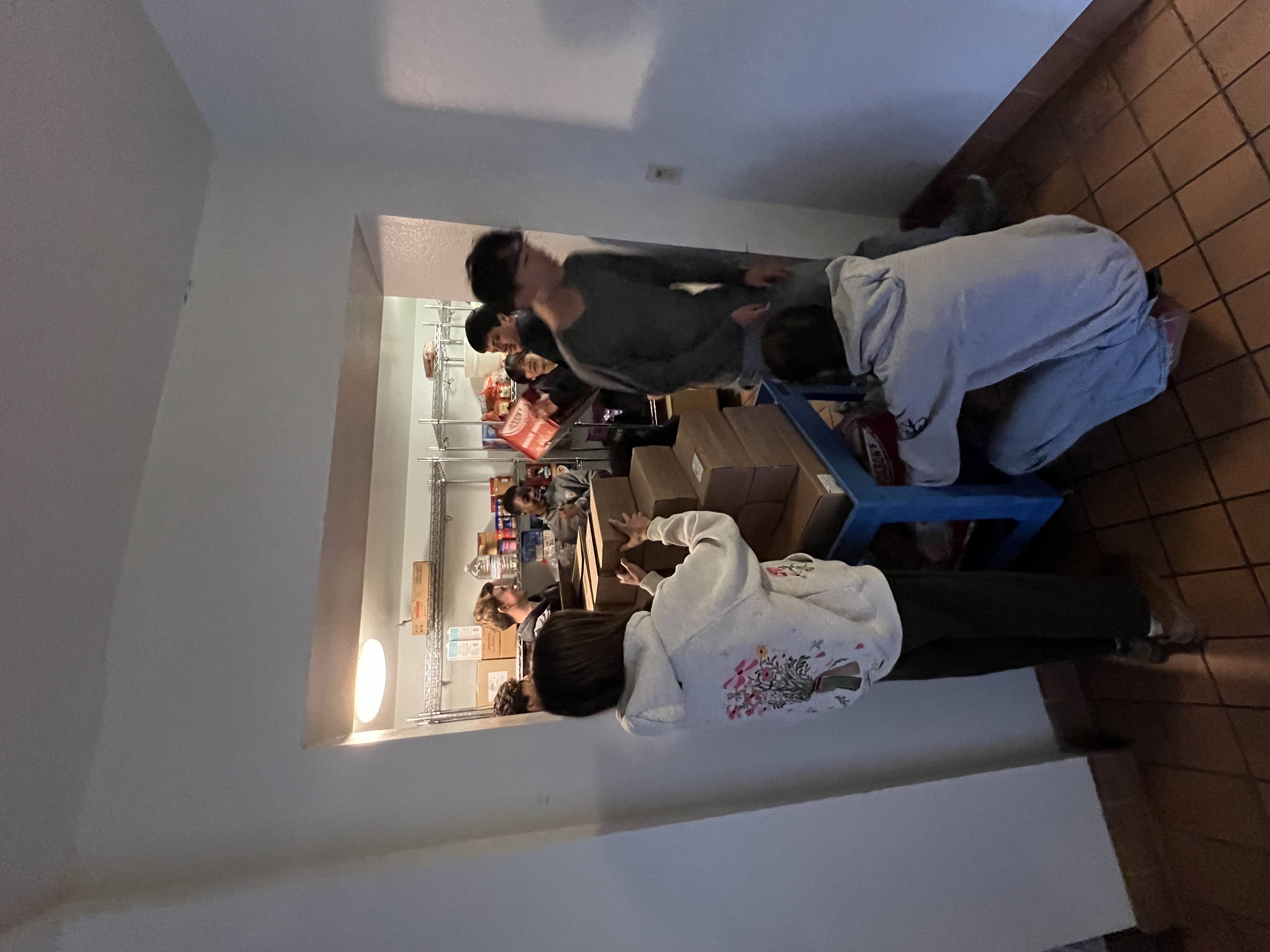 Volunteers carrying food boxes into the pantry