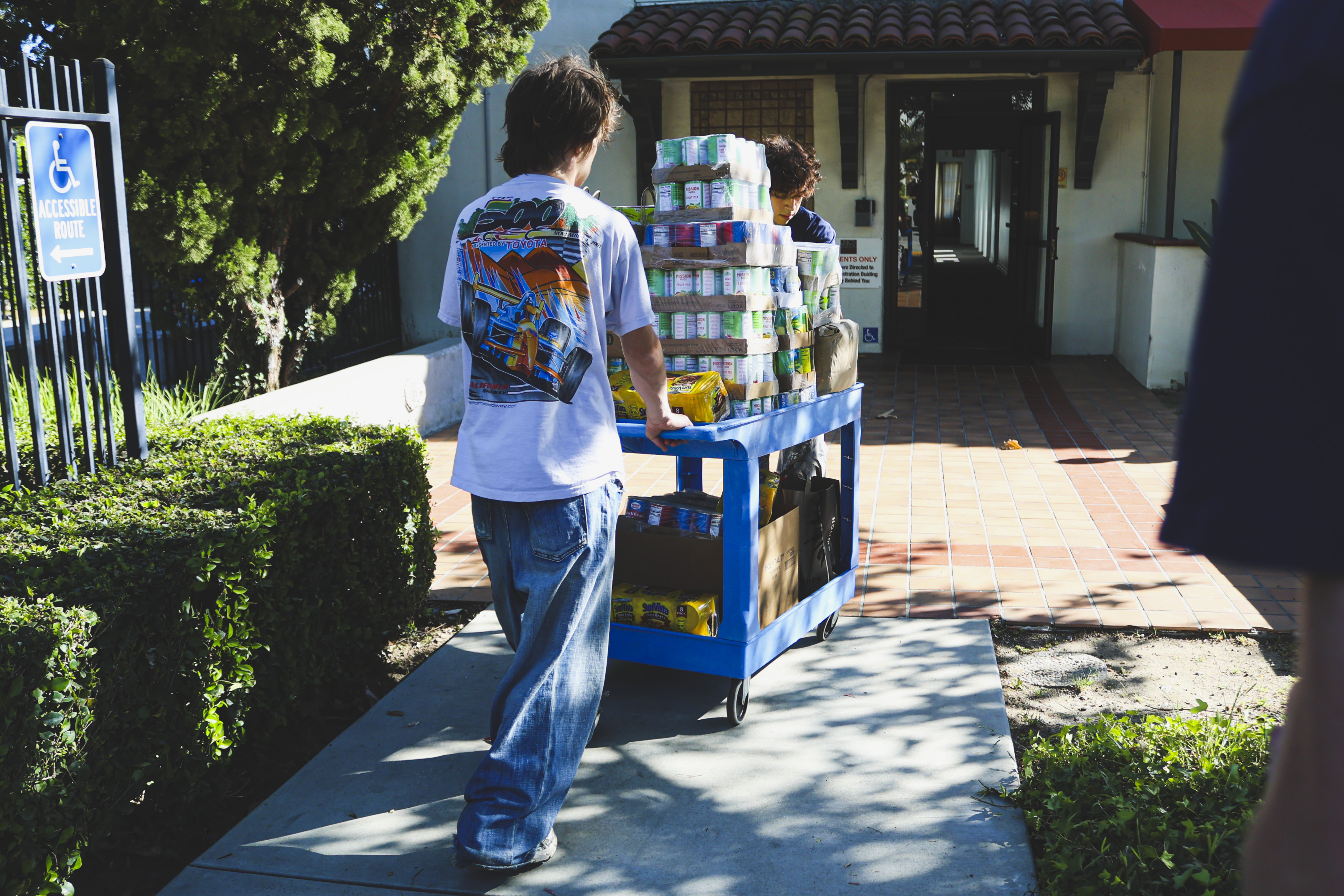 Volunteers pushing a cart loaded with allergen-friendly food donations